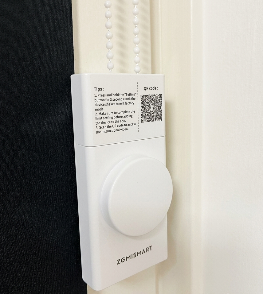 The Zemismart Roller Shade Driver mounted inside a window frame.